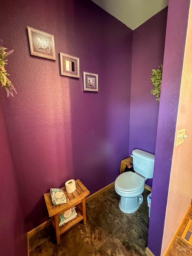 bathroom featuring baseboards, toilet, and tile patterned floors