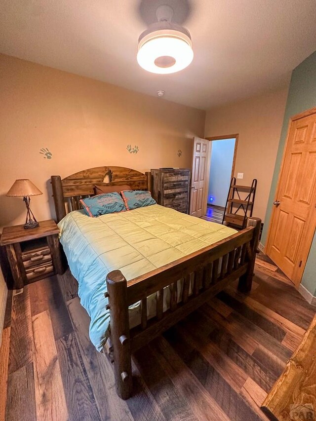 bedroom with baseboards and dark wood-style flooring