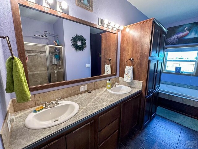 full bath with tile patterned flooring, double vanity, a sink, and a bath