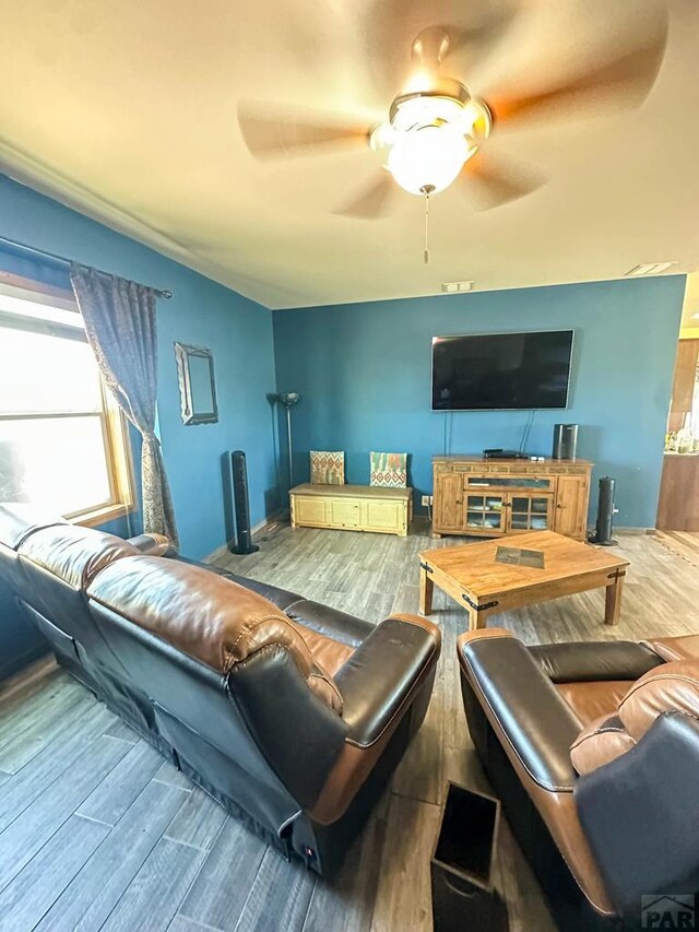 living room featuring a ceiling fan and wood finished floors