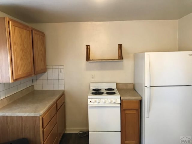 kitchen with white appliances, brown cabinets, and backsplash