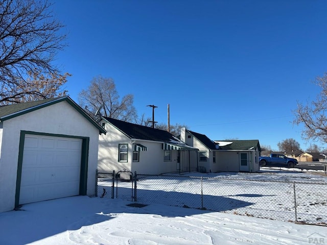 view of front of home with an attached garage, fence, and stucco siding