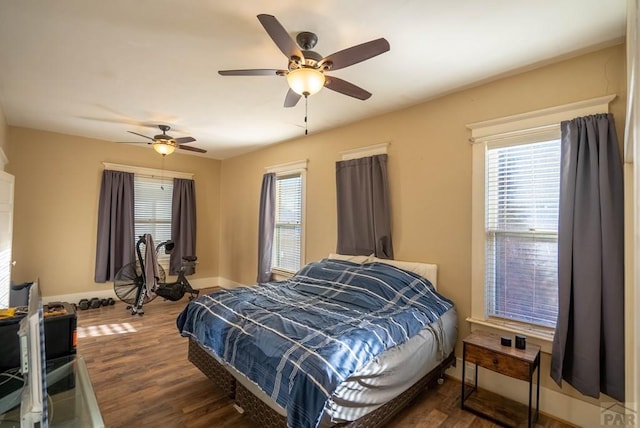 bedroom featuring dark wood-type flooring, ceiling fan, and baseboards