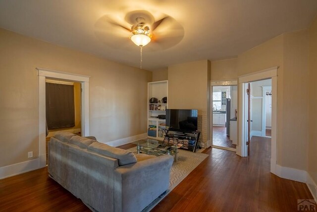 living room featuring baseboards and dark wood finished floors