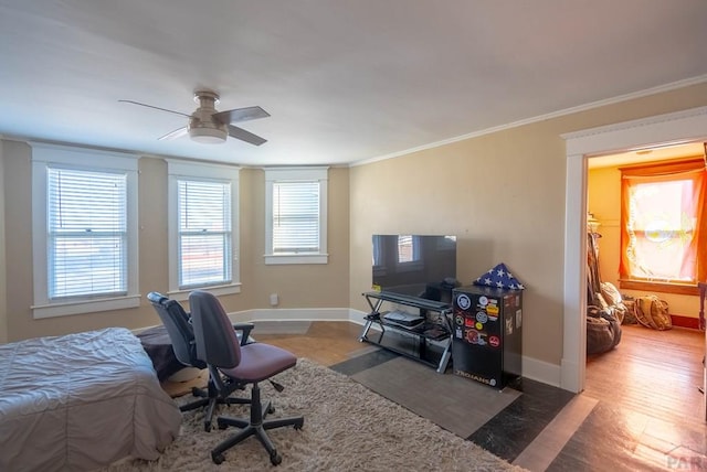 bedroom with ornamental molding, wood finished floors, a ceiling fan, and baseboards