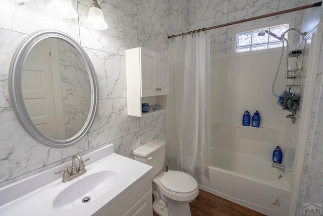 full bathroom with tile walls, shower / bathtub combination with curtain, toilet, vanity, and wood finished floors