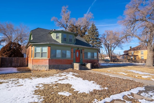 bungalow-style house with brick siding and fence