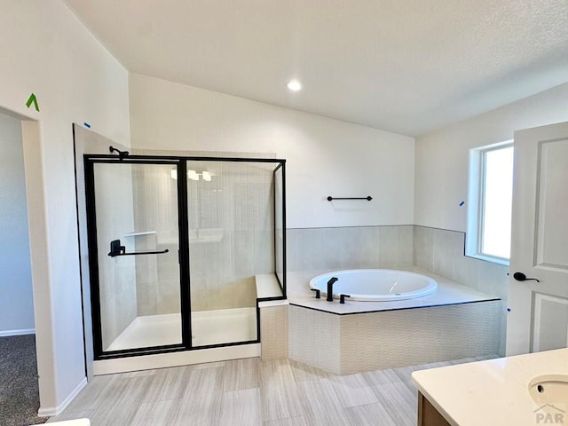 full bathroom with a bath, a shower stall, and vanity