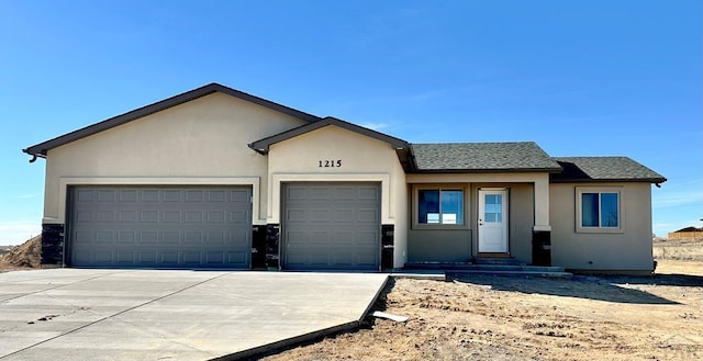 single story home featuring driveway, a shingled roof, an attached garage, and stucco siding