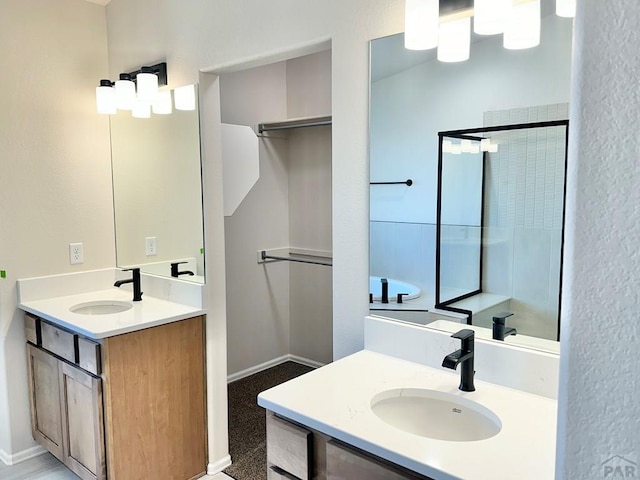 full bath featuring baseboards, two vanities, and a sink