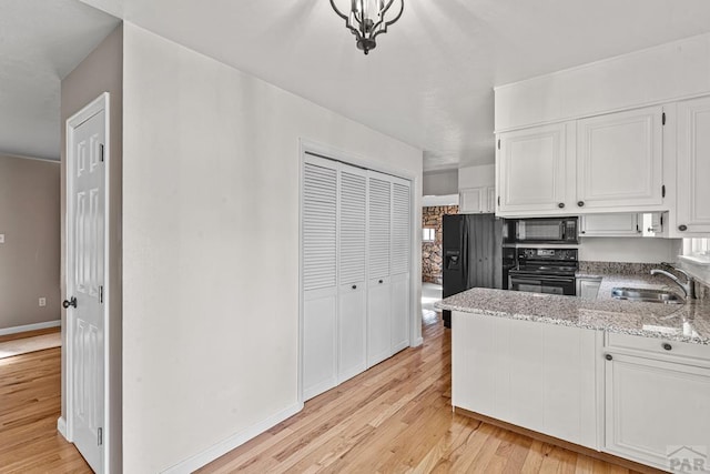 3216 Baltimore Ave, Pueblo, CO 81008 - kitchen featuring black appliances, light wood finished floors, white cabinetry, light stone counters, and a peninsula