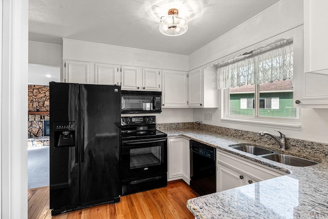 3216 Baltimore Ave, Pueblo, CO 81008 - kitchen with black appliances, light stone counters, light wood finished floors, and white cabinetry