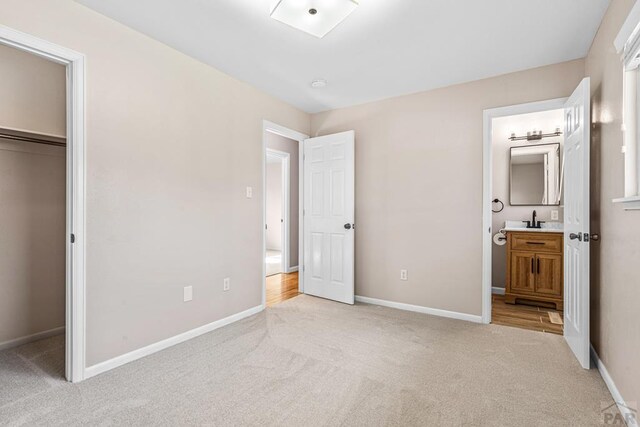 3216 Baltimore Ave, Pueblo, CO 81008 - unfurnished bedroom featuring light colored carpet, ensuite bath, a spacious closet, and a closet