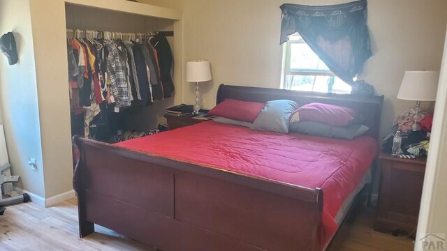 bedroom featuring a closet, baseboards, and wood finished floors