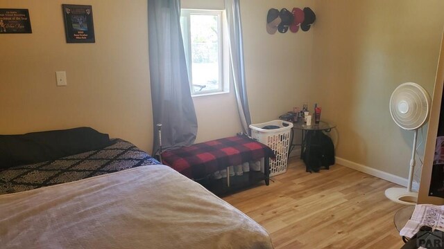 bedroom with baseboards and wood finished floors