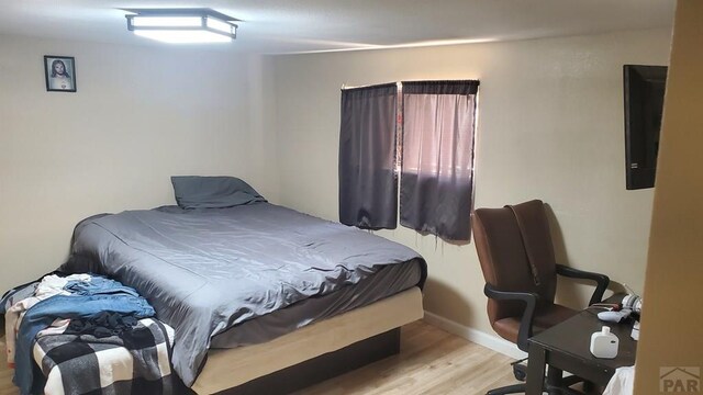 bedroom with wood finished floors and baseboards