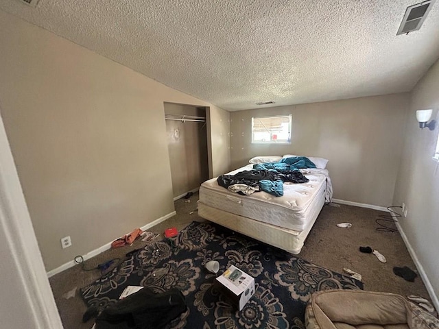 bedroom with a textured ceiling, carpet floors, a closet, and baseboards