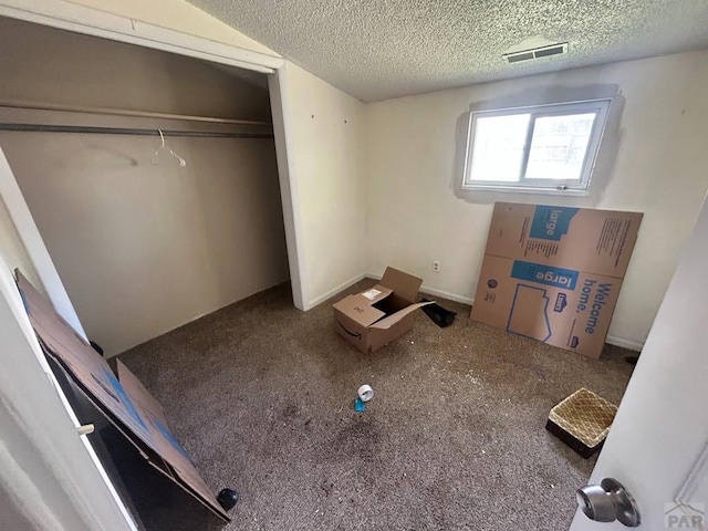 unfurnished bedroom featuring a textured ceiling, carpet, and a closet