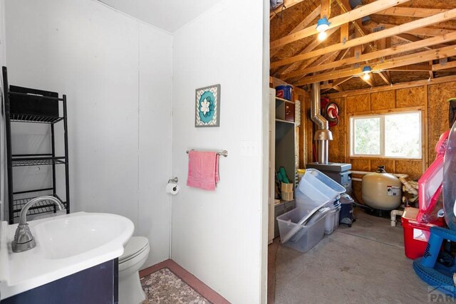 bathroom with concrete flooring, a sink, and toilet