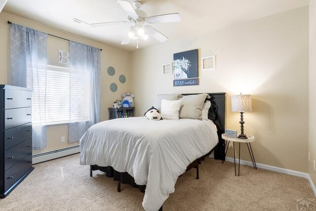 bedroom featuring a ceiling fan, carpet, a baseboard heating unit, and baseboards