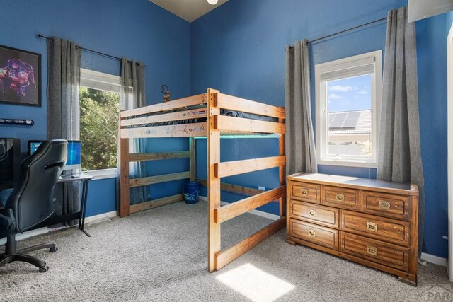 bedroom with baseboards and light colored carpet