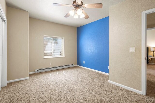 unfurnished bedroom with baseboards, a ceiling fan, a textured wall, carpet, and baseboard heating