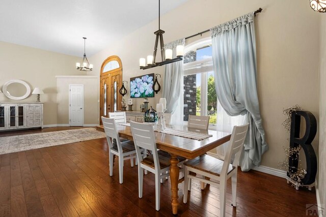 dining area with a chandelier, dark wood-type flooring, and baseboards