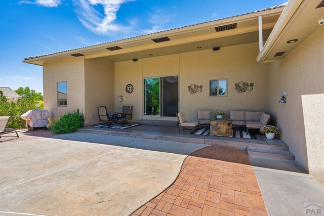 exterior space with stucco siding, an outdoor hangout area, and a patio