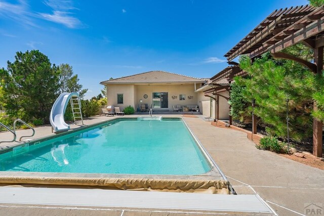 pool featuring a patio, a pergola, and a water slide