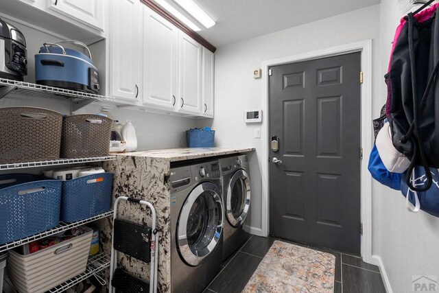 laundry room with cabinet space, washing machine and dryer, and baseboards