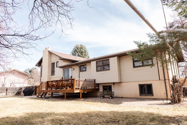 rear view of property featuring a deck and fence