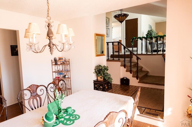 dining room featuring stairway, baseboards, an inviting chandelier, and wood finished floors