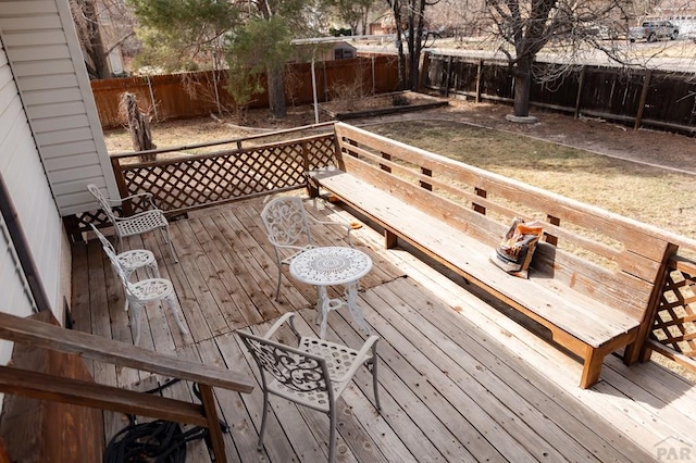 wooden deck with a fenced backyard