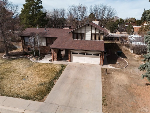 view of front of house with a front yard, a shingled roof, concrete driveway, a garage, and brick siding