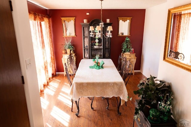 dining area with baseboards and wood finished floors