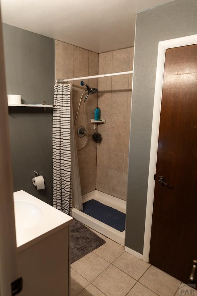 full bath with tile patterned flooring, a shower stall, and vanity