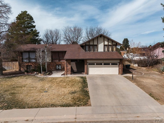 view of front of home featuring brick siding, an attached garage, concrete driveway, and a front yard