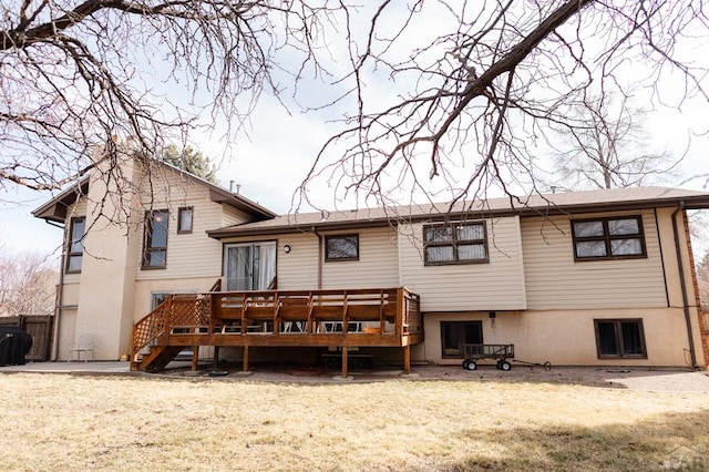 rear view of house with stairway, a lawn, and a wooden deck