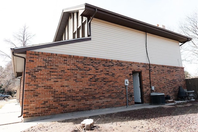 view of home's exterior with brick siding and central air condition unit