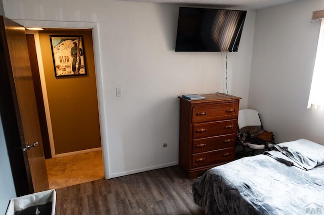 bedroom featuring baseboards and wood finished floors