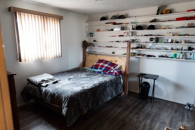 bedroom featuring a textured ceiling, baseboards, and dark wood-style flooring