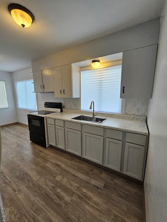 kitchen with dark wood-style flooring, a sink, light countertops, gray cabinets, and black electric range oven