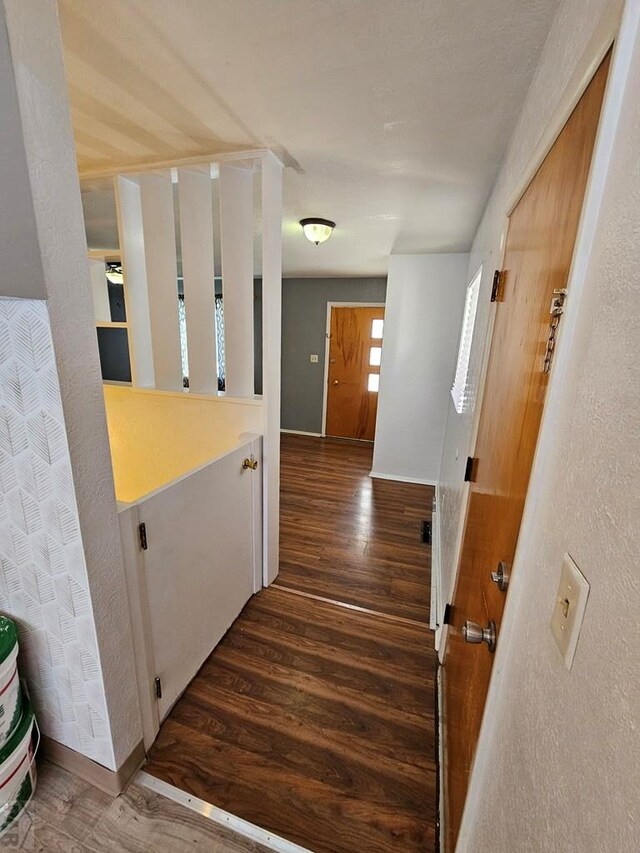 hall with dark wood-style floors and baseboards