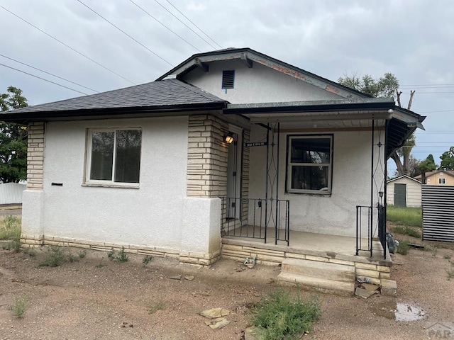 1540 E 13th St, Pueblo, CO 81001 - bungalow-style house with stucco siding, roof with shingles, and covered porch
