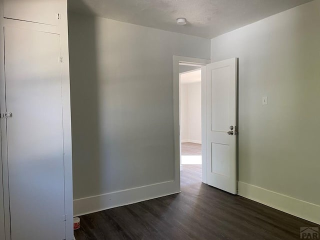 1540 E 13th St, Pueblo, CO 81001 - unfurnished room with dark wood-type flooring, baseboards, and a smoke detector