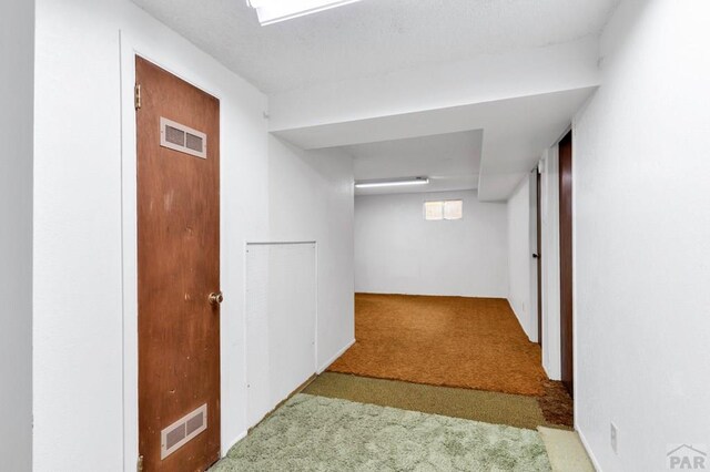 corridor with light colored carpet and visible vents