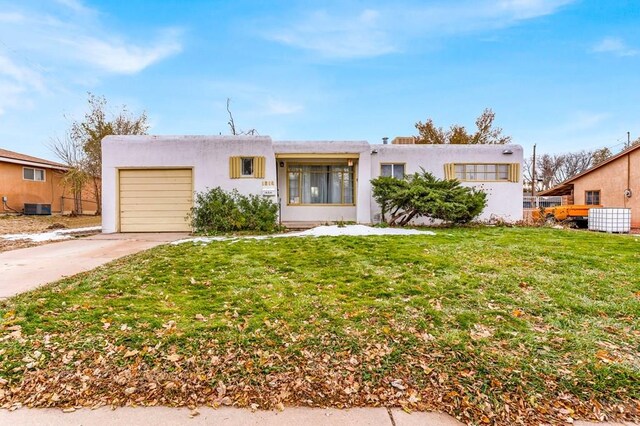 view of front of home featuring a garage, driveway, cooling unit, a front lawn, and stucco siding