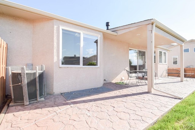 back of property featuring stucco siding, a patio, cooling unit, and fence