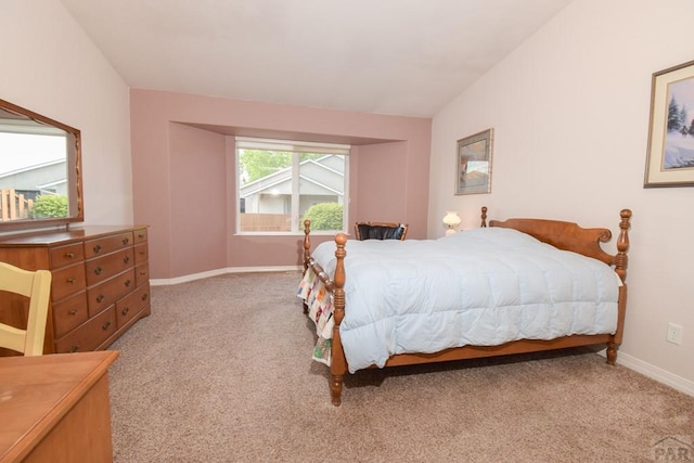 bedroom featuring light colored carpet, baseboards, and lofted ceiling