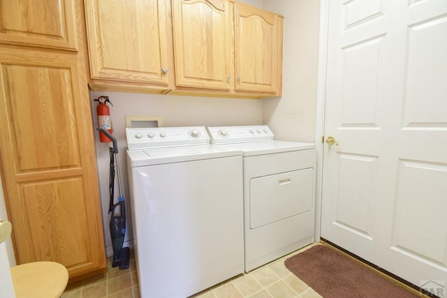 clothes washing area with washing machine and clothes dryer and cabinet space